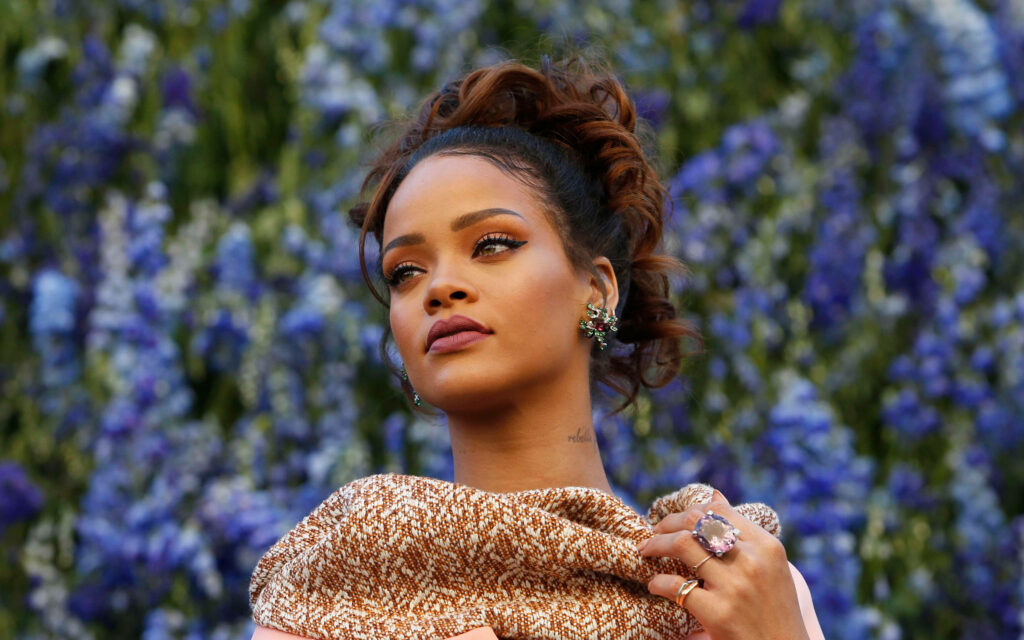Elegant Rihanna Wallpaper: Graceful Pose Amidst Vibrant Blue Flowers