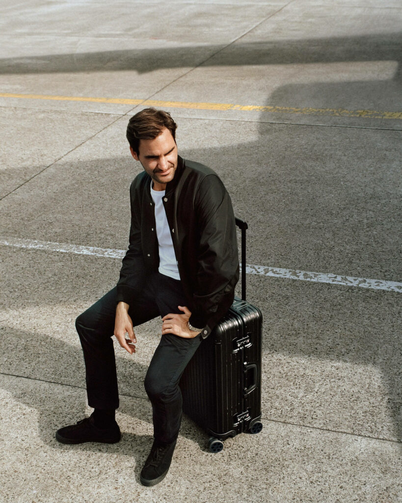 Elegant Roger Federer Wallpaper: Stylish Outdoor Suitcase Scene