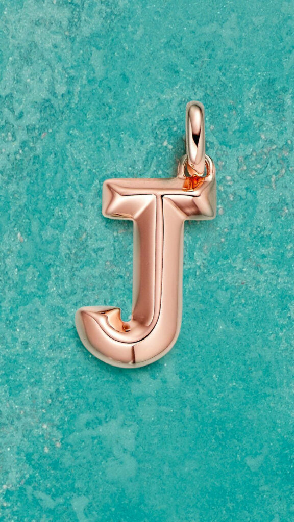 Elegant Rose Gold J Pendant on Textured Turquoise Background Wallpaper