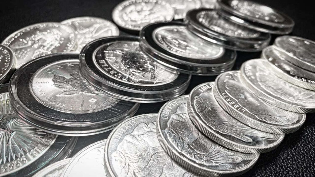 Elegant Silver Coins Wallpaper: Intricate Designs on Dark Background