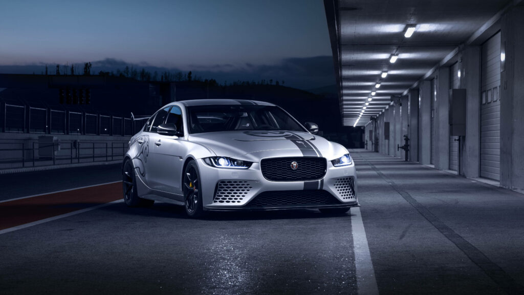 Sleek Silver Jaguar Wallpaper: Luxury Car on Dimly Lit Racetrack Garage
