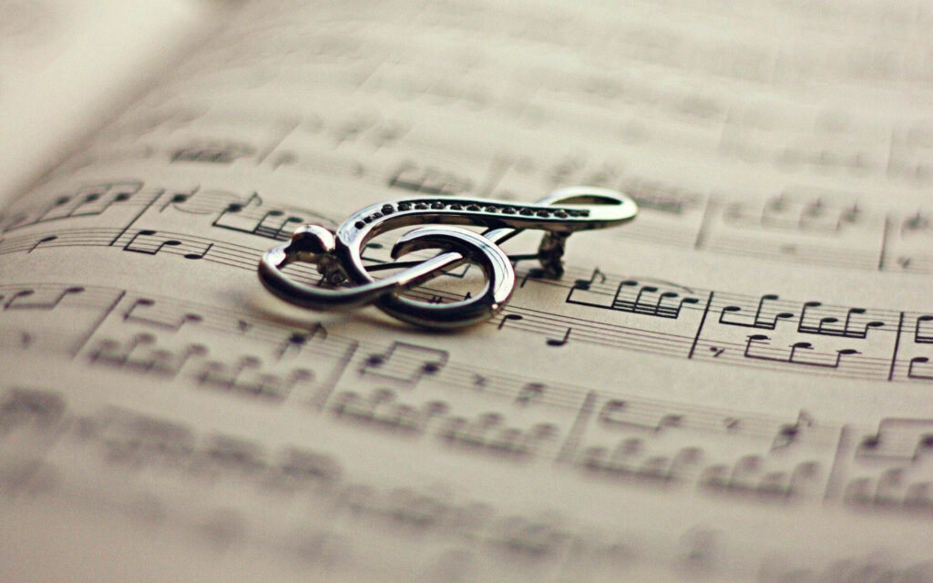 Elegant Silver Treble Clef Pendant on Musical Notes – Wallpaper Background