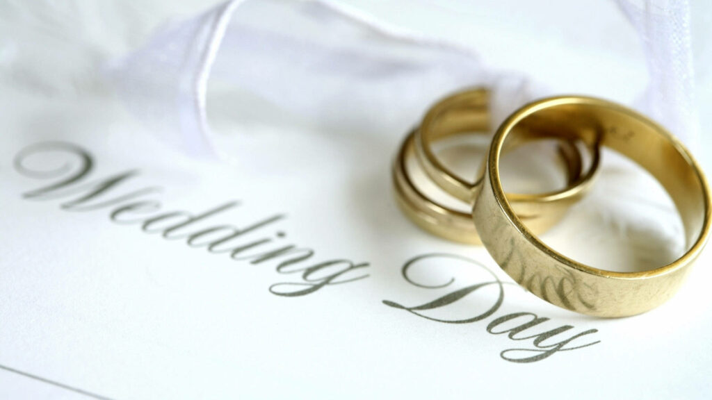 Elegant Symbol of Love: A Stunning Wedding Invitation featuring Golden Rings Wallpaper