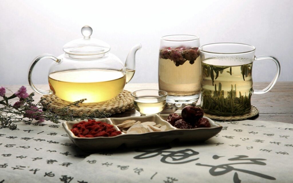 Elegant Tea Set Wallpaper: Glass Teapots & Assorted Teas Background