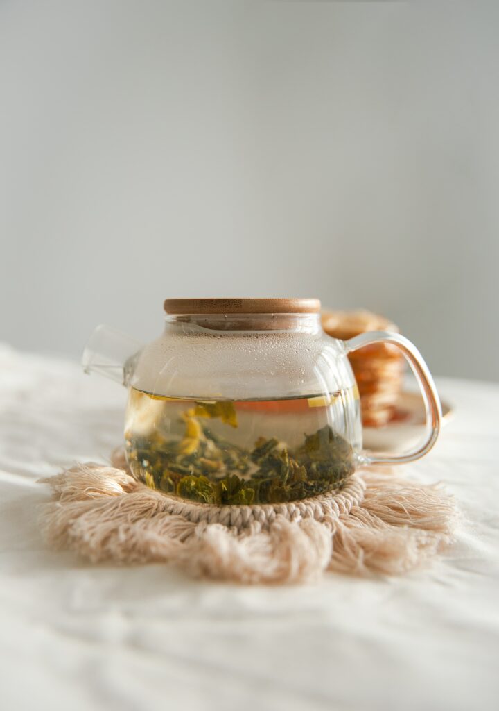 Elegant Transparent Glass Kettle with Hot Tea - Warm Wallpaper Background
