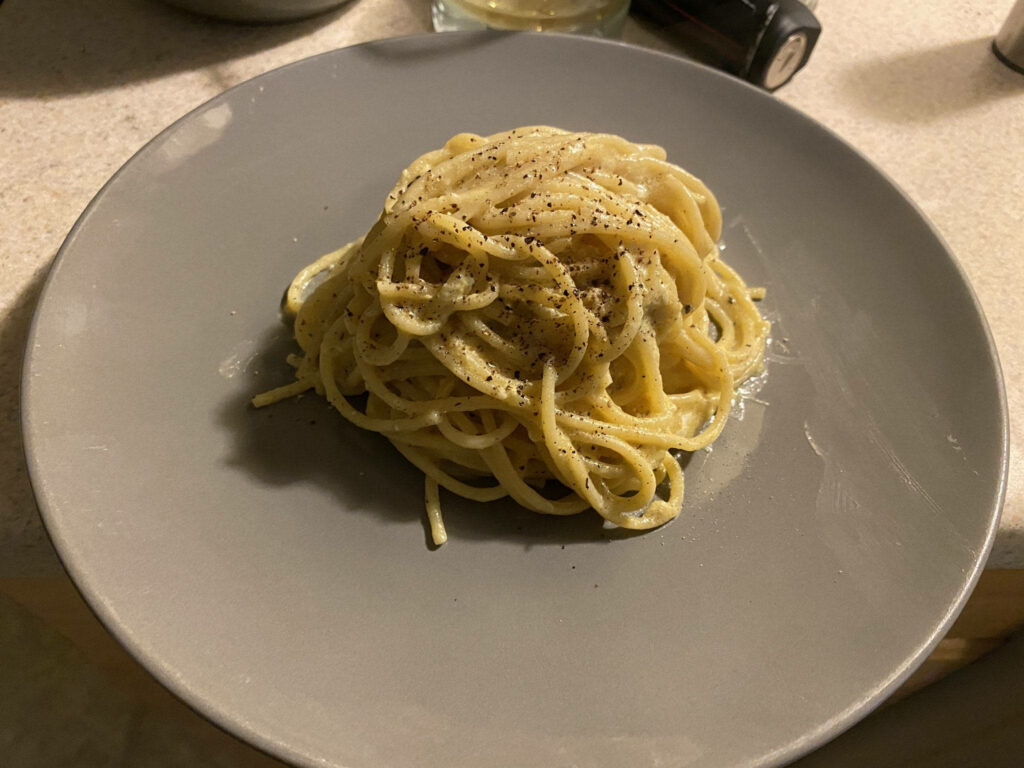 Elegant Wallpaper: Grey Plate with Cacio e Pepe Pasta Dish Background