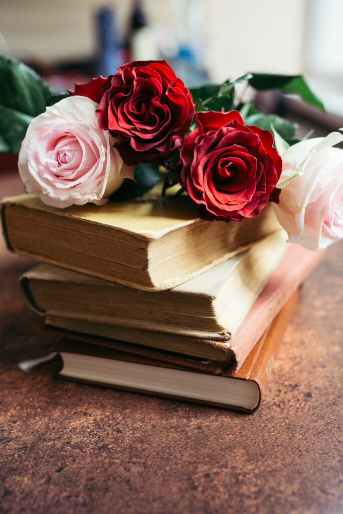 Elegant Red & Pink Roses Background on Vintage Books - Serene Decor Wallpaper