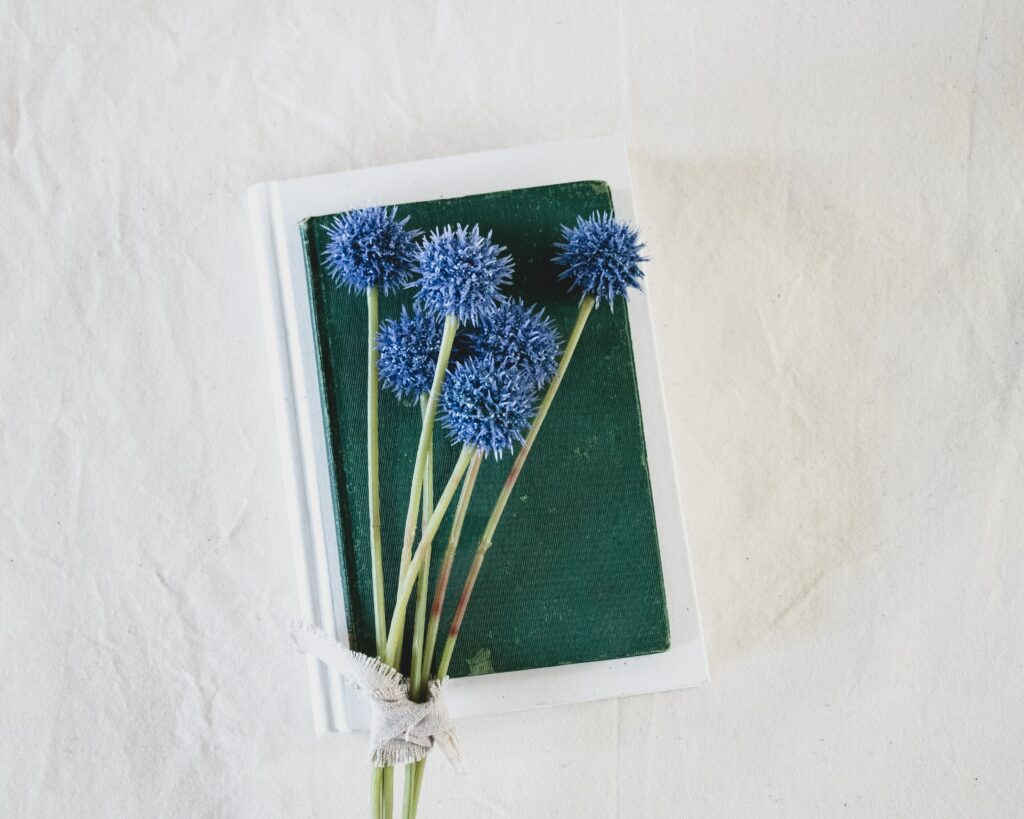 Elegant Wallpaper: Blue Flowers on Books with Neutral Background