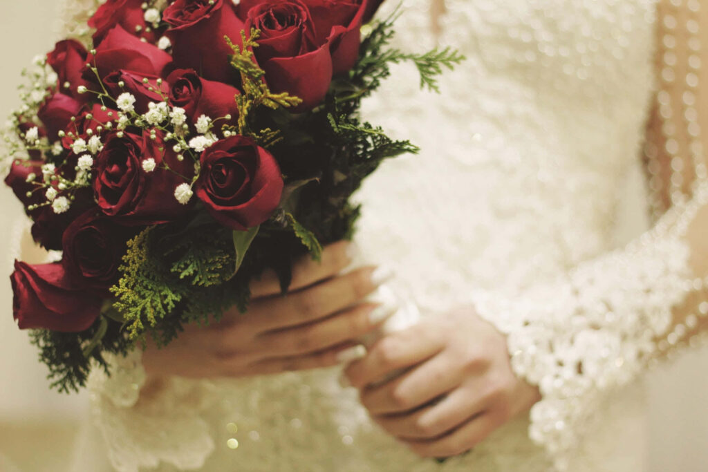 Elegant Wedding Bouquet of Deep Red Roses in Lush Greenery Background Wallpaper