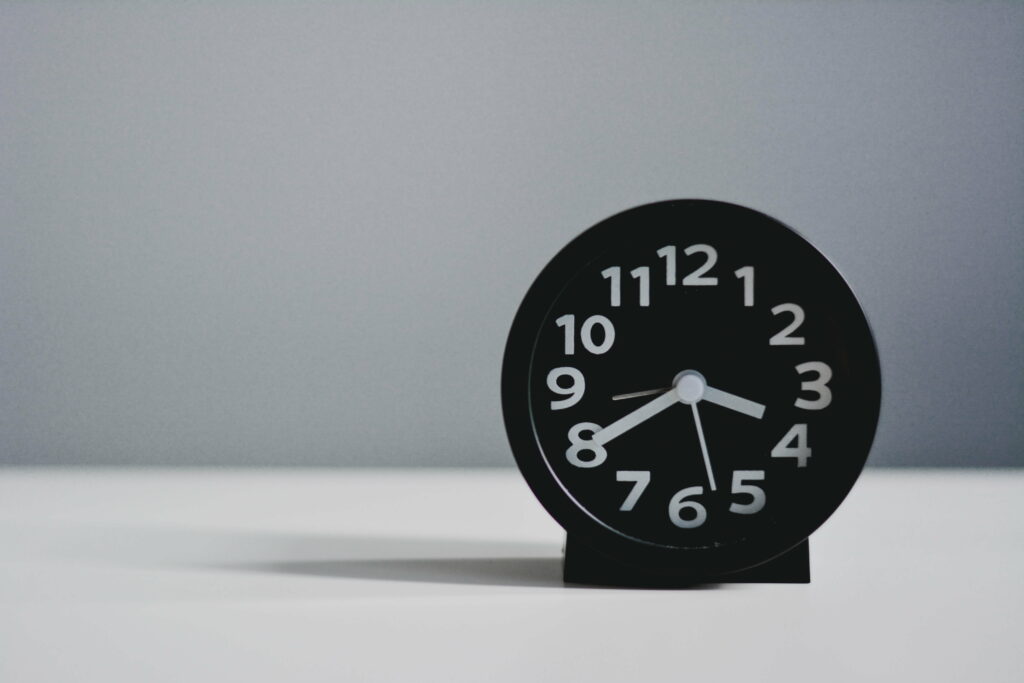 Time Flows in Numbers: A White 4K Wallpaper featuring an Alarm Clock