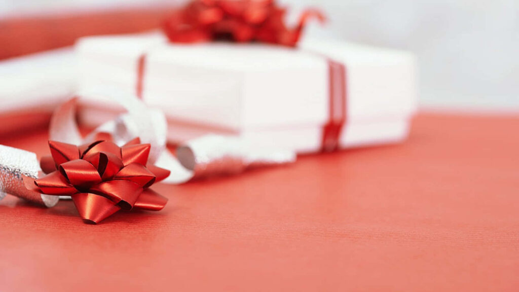 White gift box with red ribbon on red surface perfect for prenup gift wallpaper background
