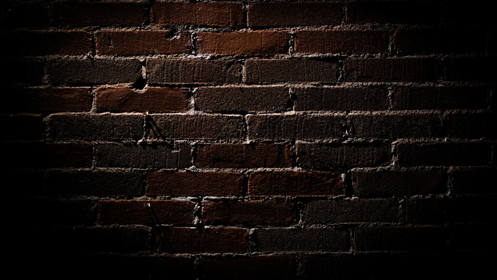 Enigmatic Depths: Captivating Brick Texture Immersed in Dim Light Wallpaper