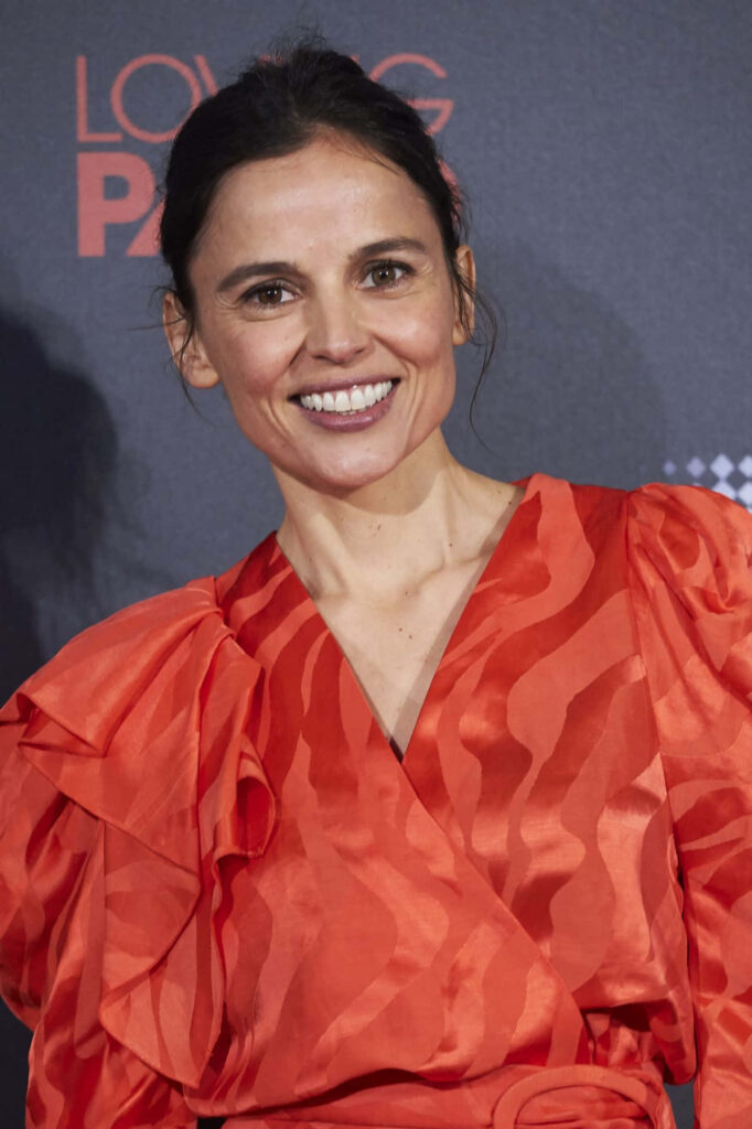 Elena Anaya in vibrant red patterned dress against dark backdrop confident elegant portrait Wallpaper