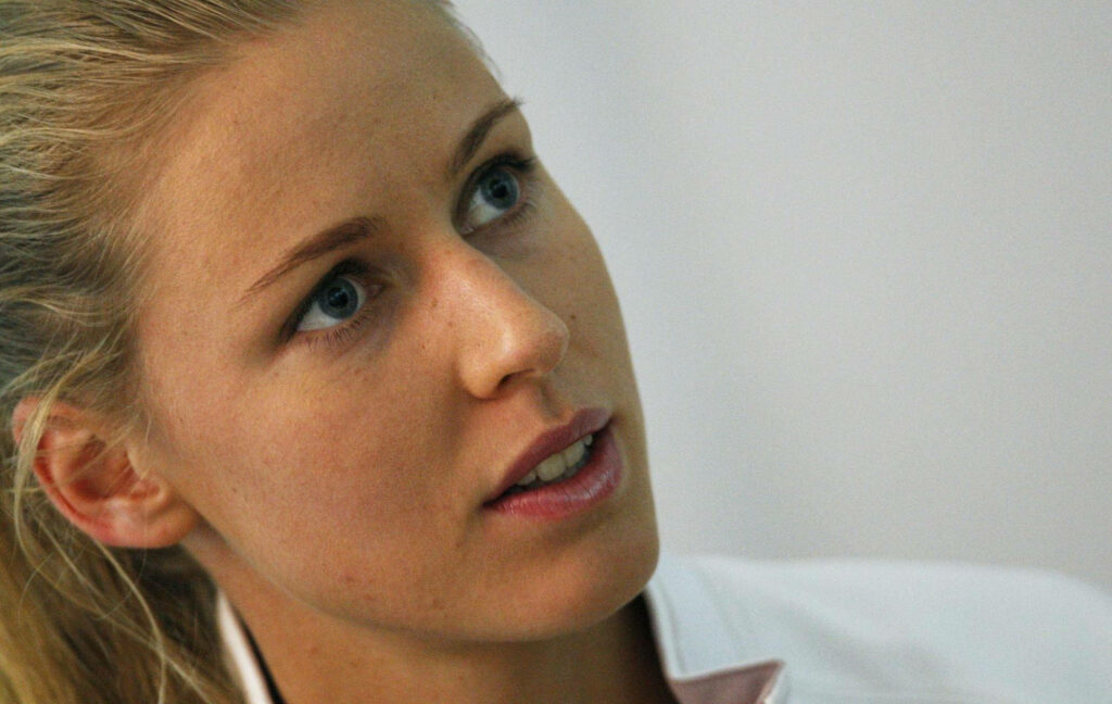 Close-up portrait of young Elena Dementieva with focused expression soft lighting wallpaper background