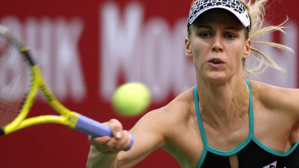 Elena Dementieva intense tennis action stretching to hit ball vivid colors red background wallpaper