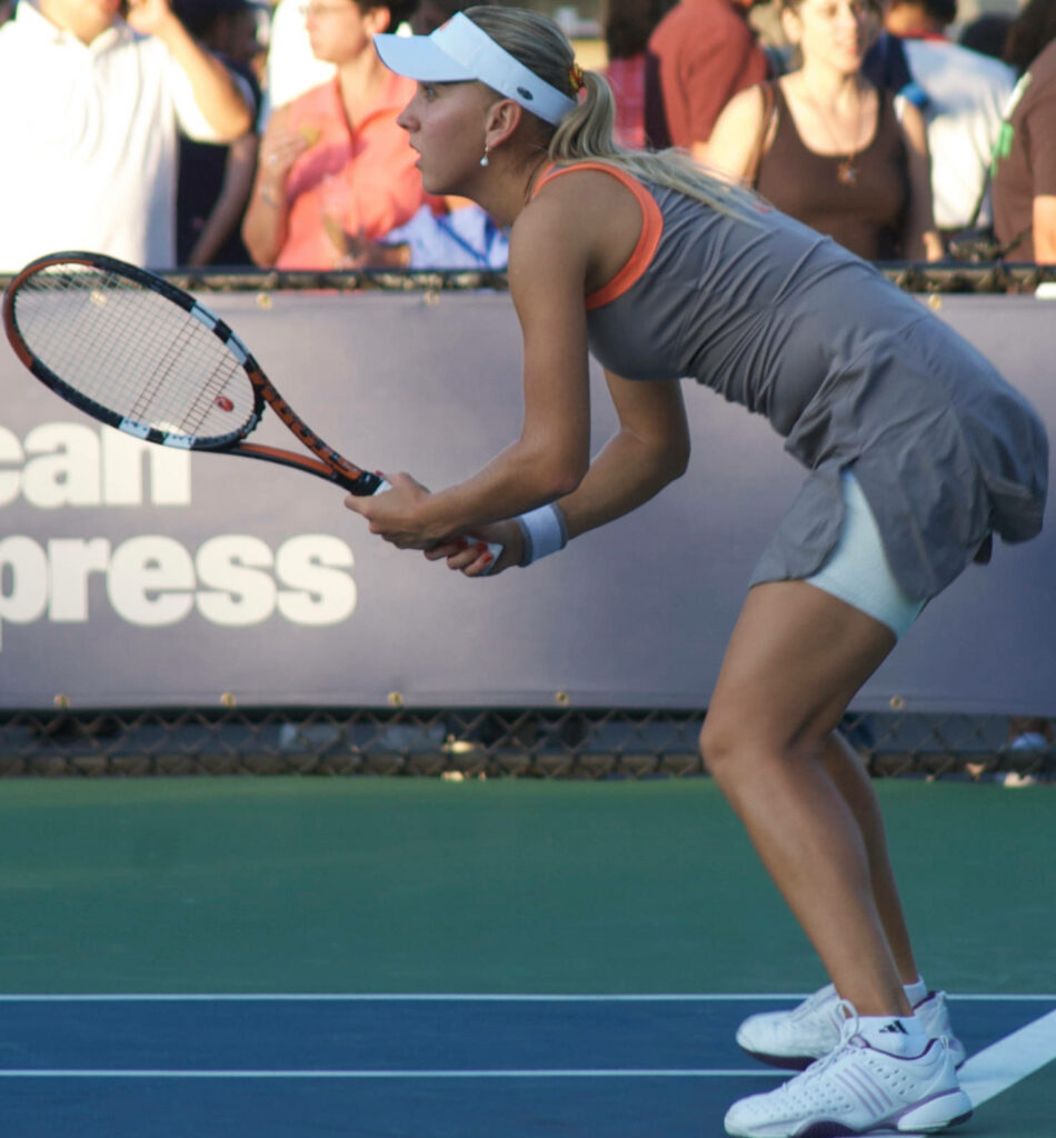 Elena Vesnina focused in gray sports dress holding tennis racket ready on court with crowd background Wallpaper