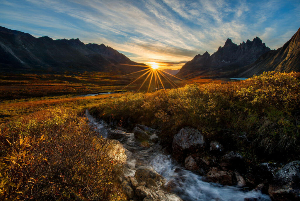 Breathtaking Mountain Sunset Paints a Vivid Canvas While a Majestic Stream Winds through Golden Grass - Captivating HD Mountain Landscape Wallpaper