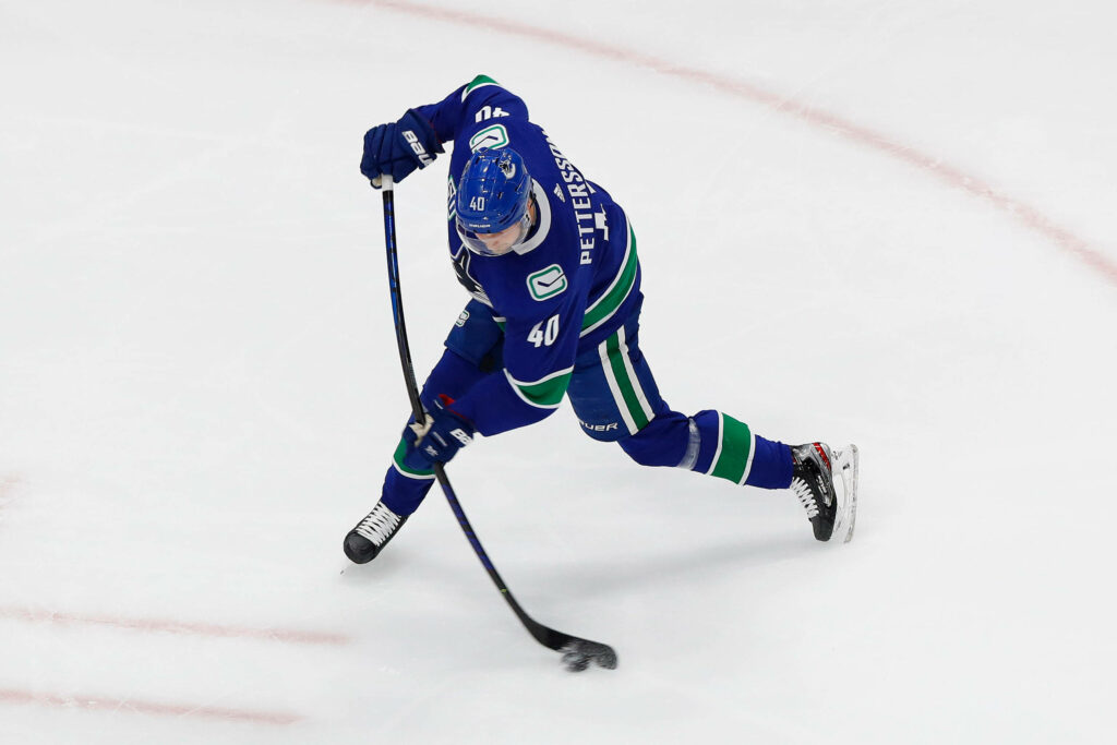 Elias Pettersson Action Wallpaper: NHL Star in Blue Jersey