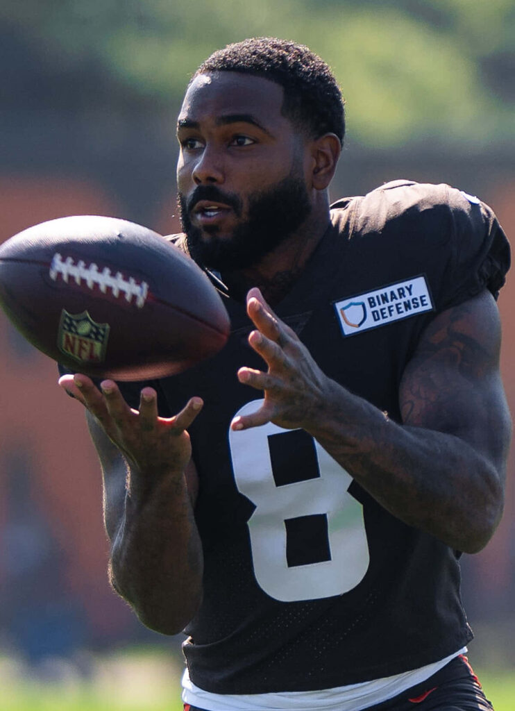 Elijah Moore Browns football practice focused catching ball athletic training intensity sunlight Wallpaper