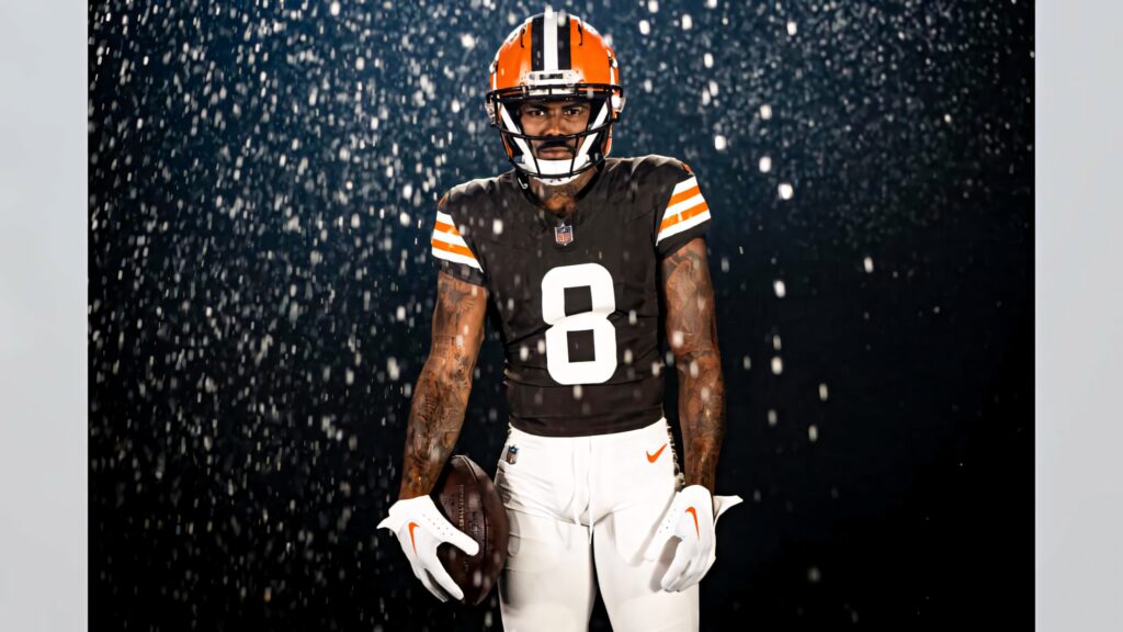 Elijah Moore in football uniform holding ball with snowy background intense sports portrait wallpaper