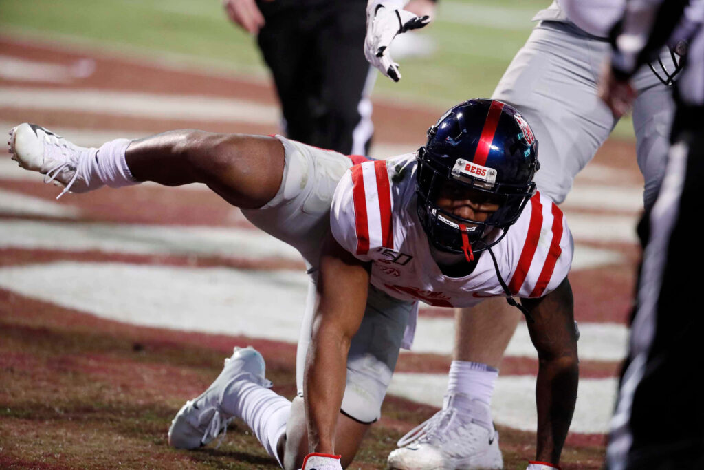 Elijah Moore Ole Miss football action shot vibrant red and blue uniform on field wallpaper background