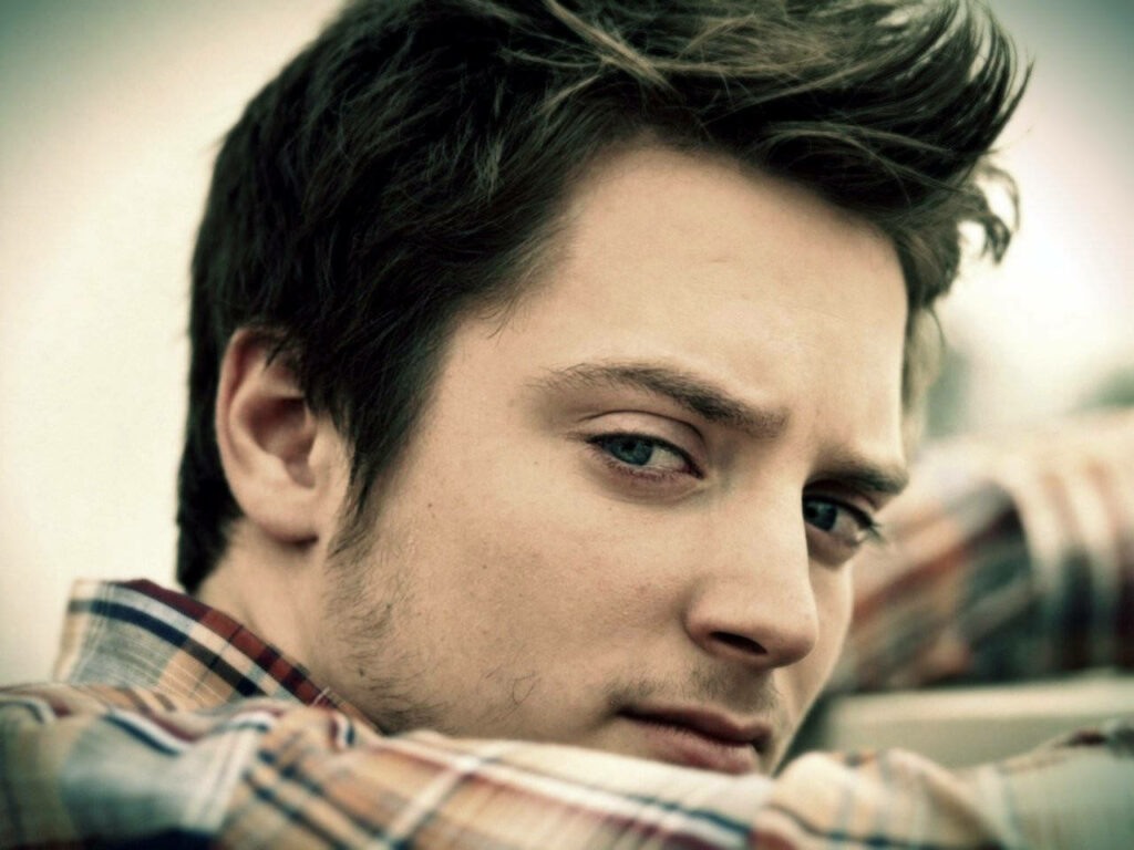 Elijah Wood close-up portrait with blue eyes soft focus muted colors plaid shirt wallpaper background