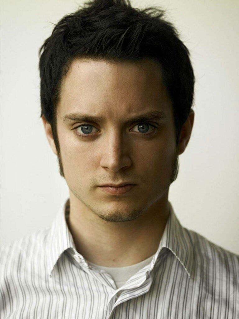 Elijah Wood portrait with intense blue eyes casual striped shirt soft neutral background wallpaper