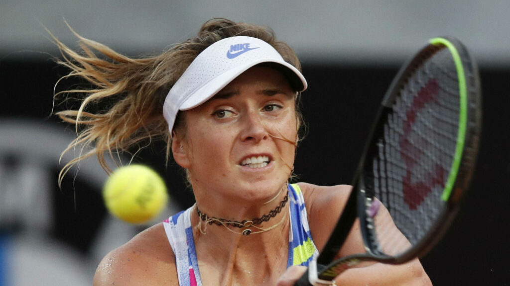 Elina Svitolina focused mid-action during tennis match showcasing athleticism and vibrant court colors Wallpaper