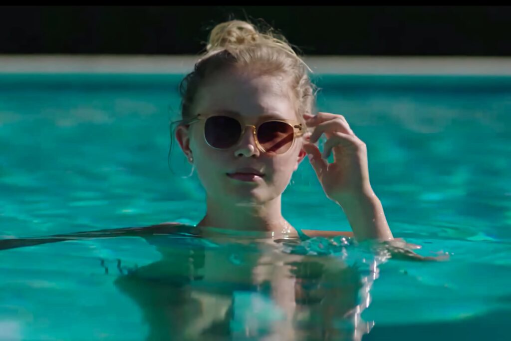 Eliza Scanlen as Amma Crellin poolside in Sharp Objects cool blue tones sunlight reflection Wallpaper