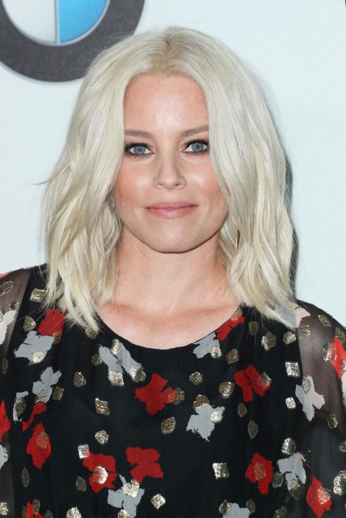 Elizabeth Banks radiant blonde hair confident smile chic patterned outfit soft wallpaper background