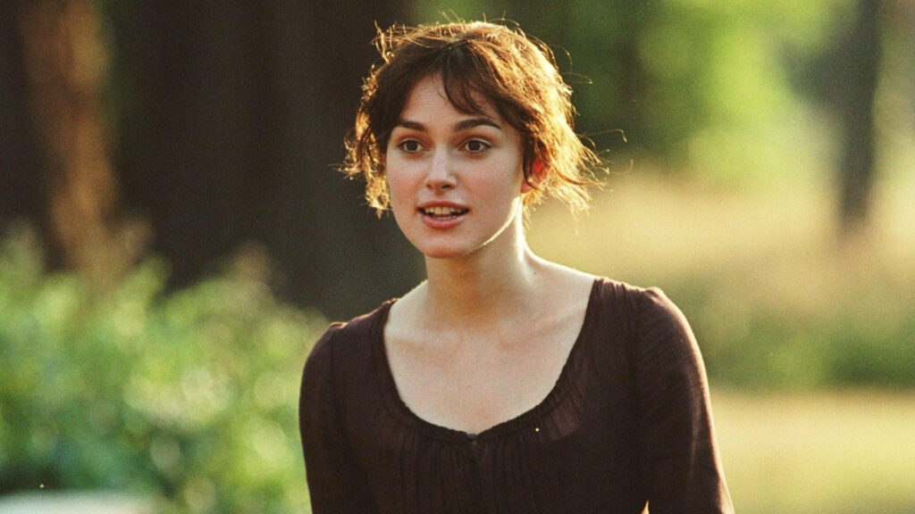 Elizabeth Bennet from Pride and Prejudice outdoors with carefree smile lush green background wallpaper