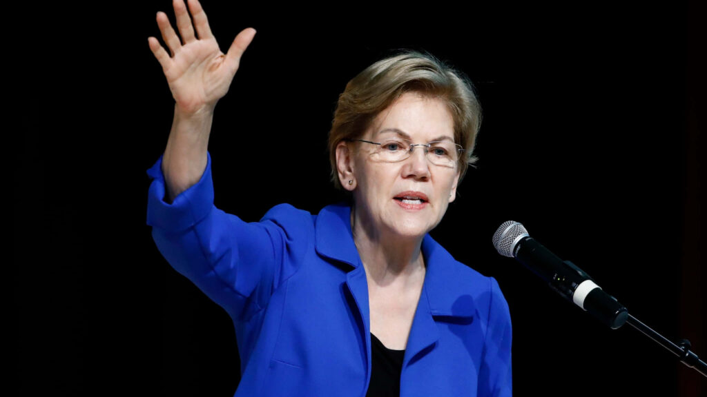 Elizabeth Warren speaking passionately at podium wearing blue blazer dynamic leadership wallpaper
