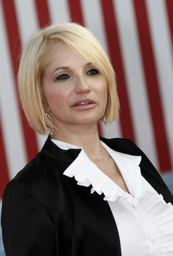 Ellen Barkin in black jacket white ruffled blouse against bold red and white stripe background wallpaper