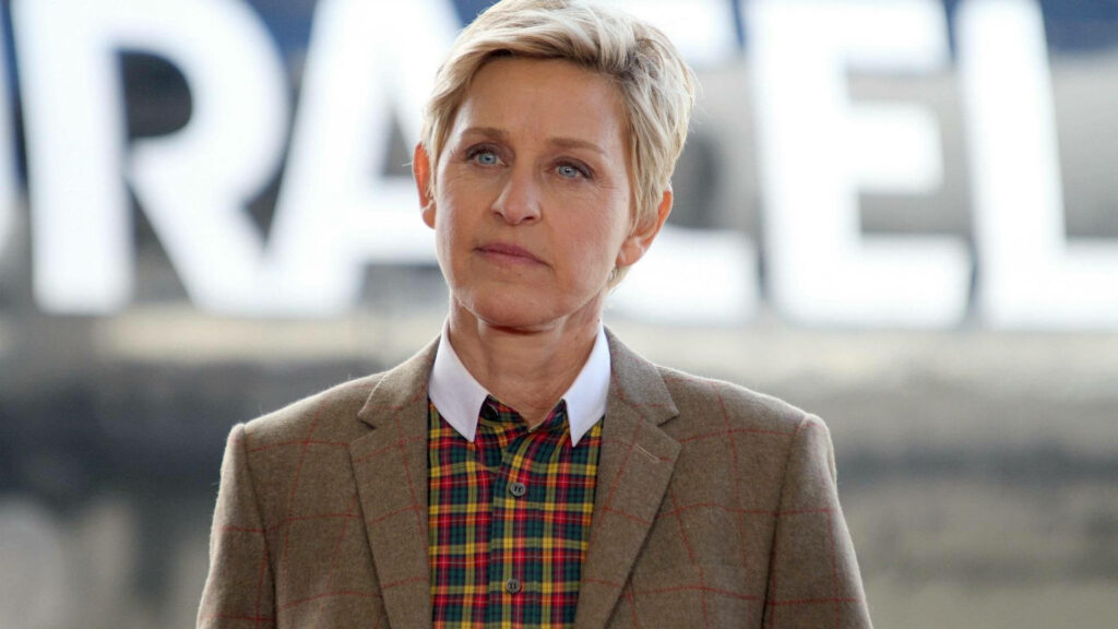 Ellen DeGeneres serious expression checked shirt brown blazer outdoor blurred background wallpaper