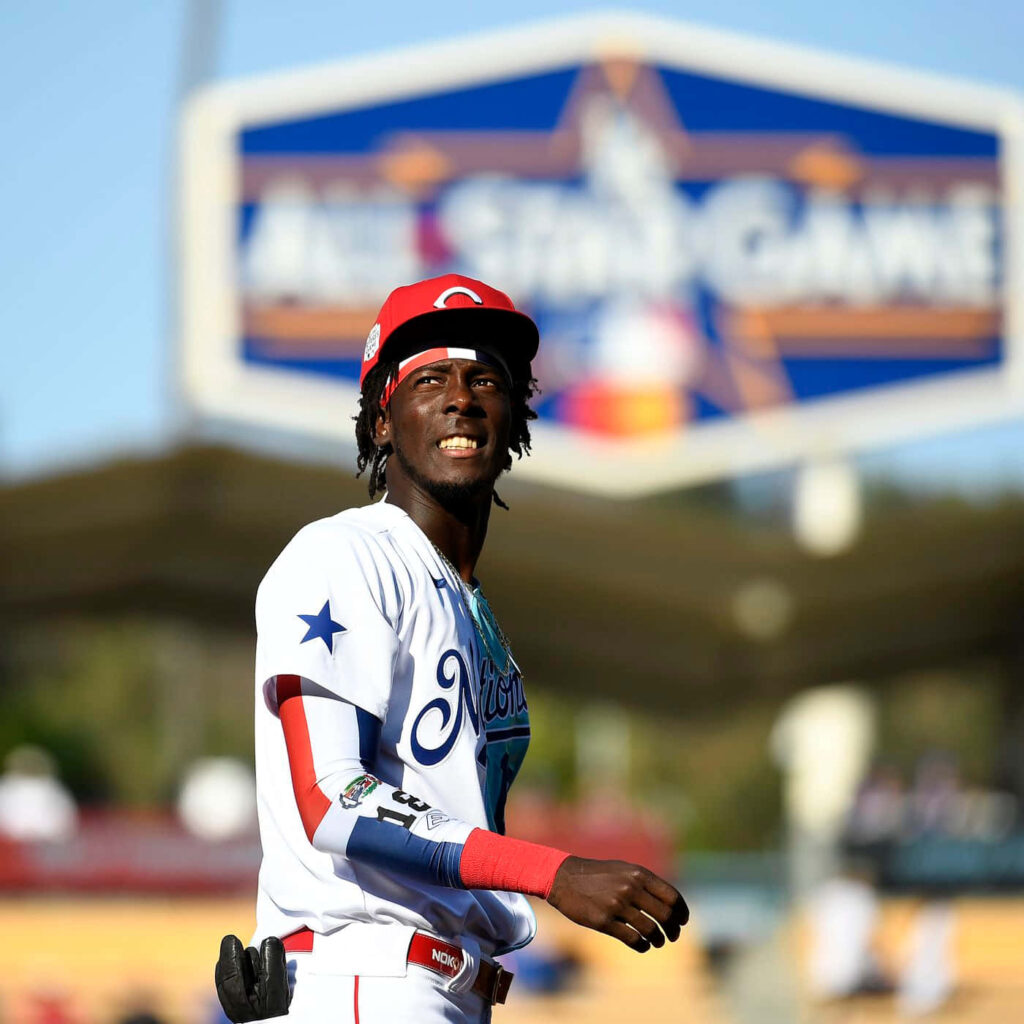 Elly De La Cruz in vibrant All-Star Game uniform on baseball field with event signage background Wallpaper