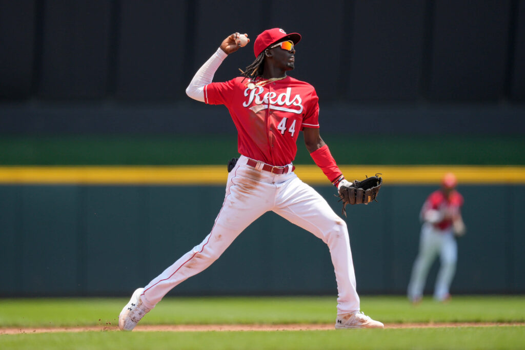 Elly De La Cruz Cincinnati Reds throwing baseball mid-action vibrant athletic wallpaper background