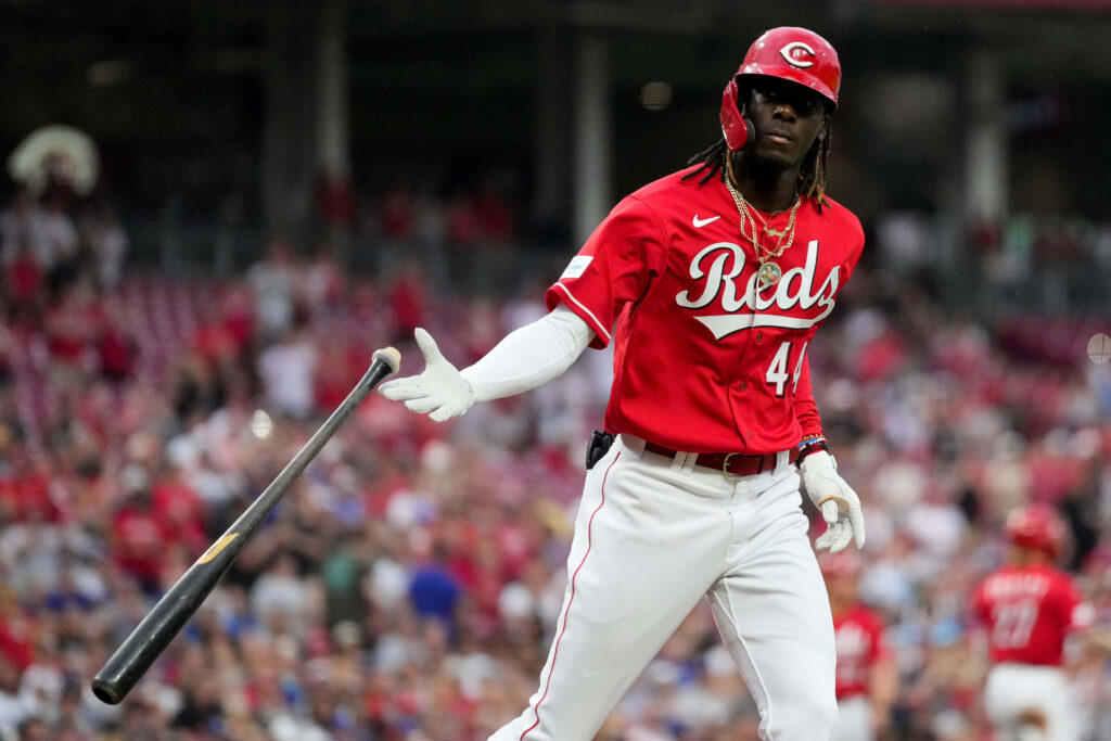Elly De La Cruz Cincinnati Reds player in red uniform tossing bat in packed stadium game scene Wallpaper