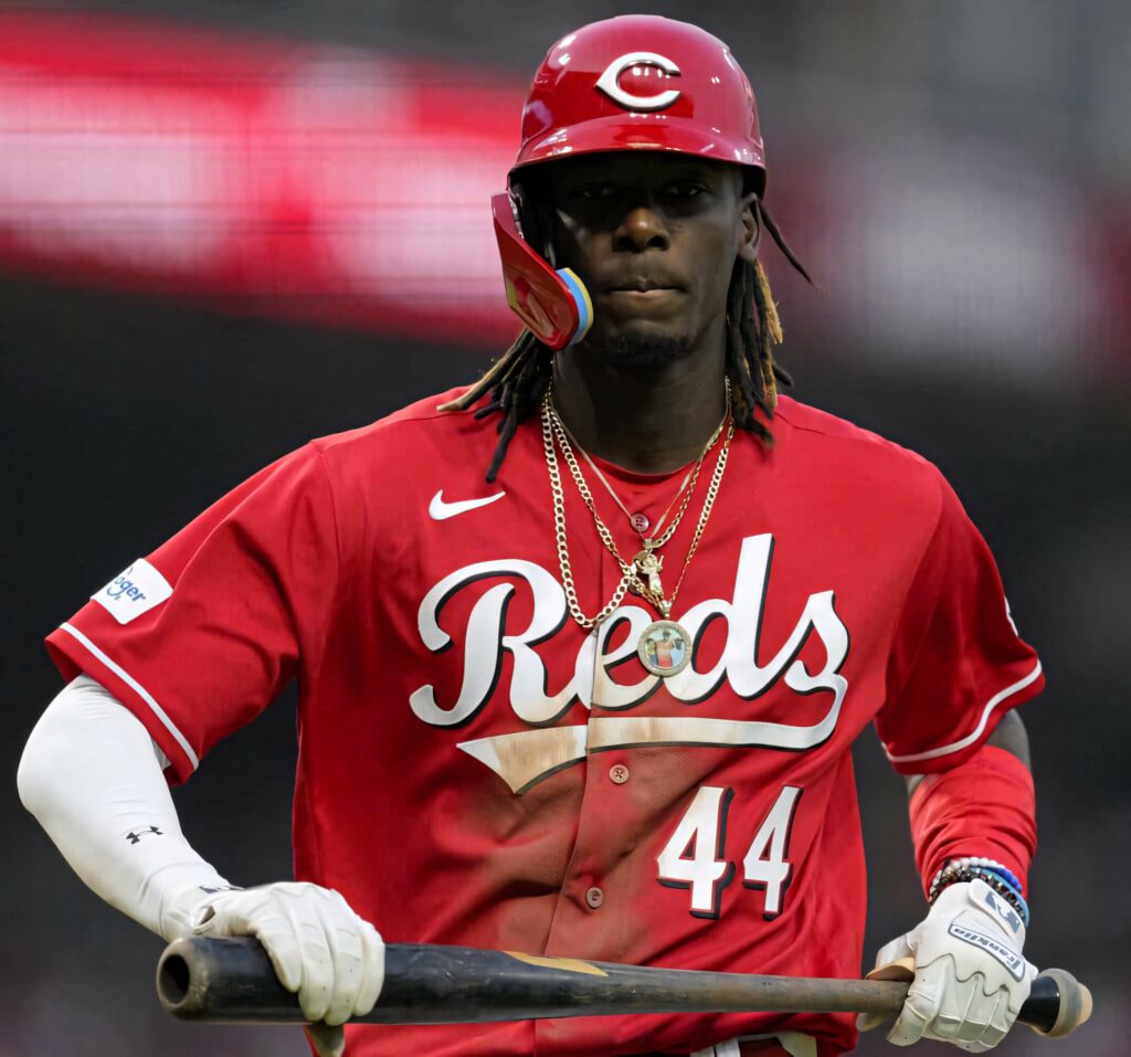 Elly De La Cruz in Cincinnati Reds uniform holding bat focused vibrant baseball wallpaper background