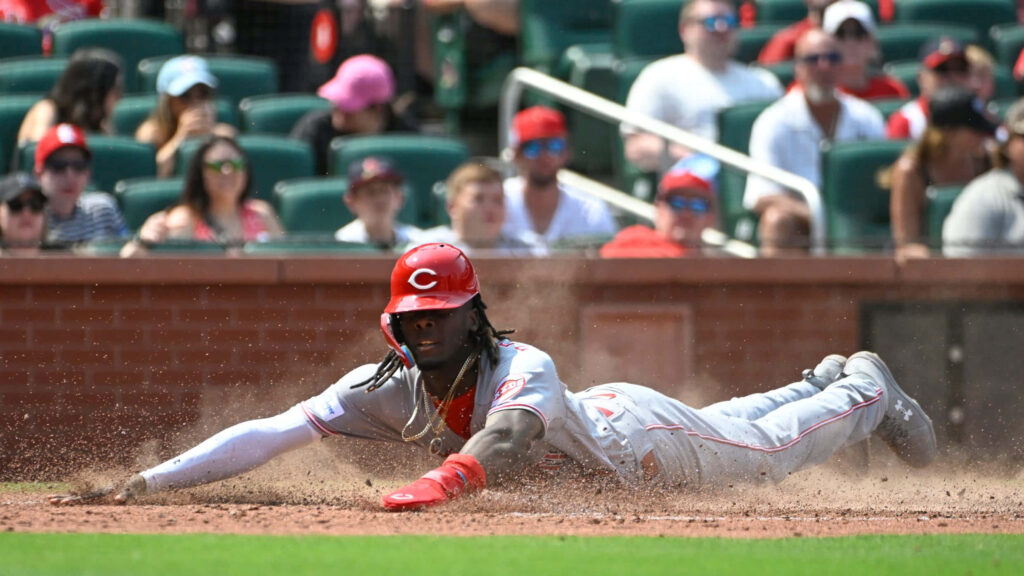 Elly De La Cruz slides headfirst into home plate in a dynamic daytime professional baseball game Wallpaper
