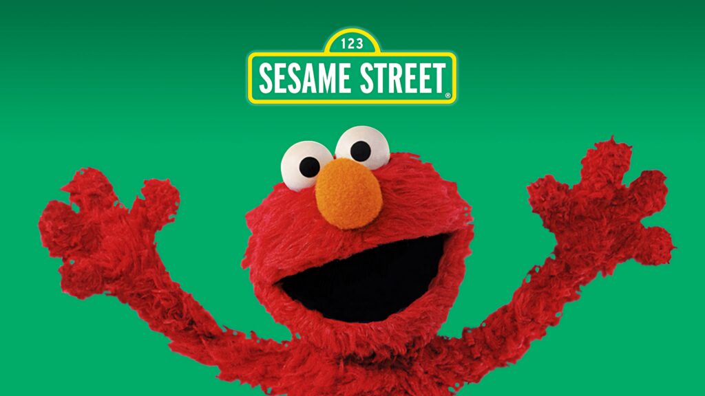 Elmo waving happily on bright green Sesame Street wallpaper with iconic logo background