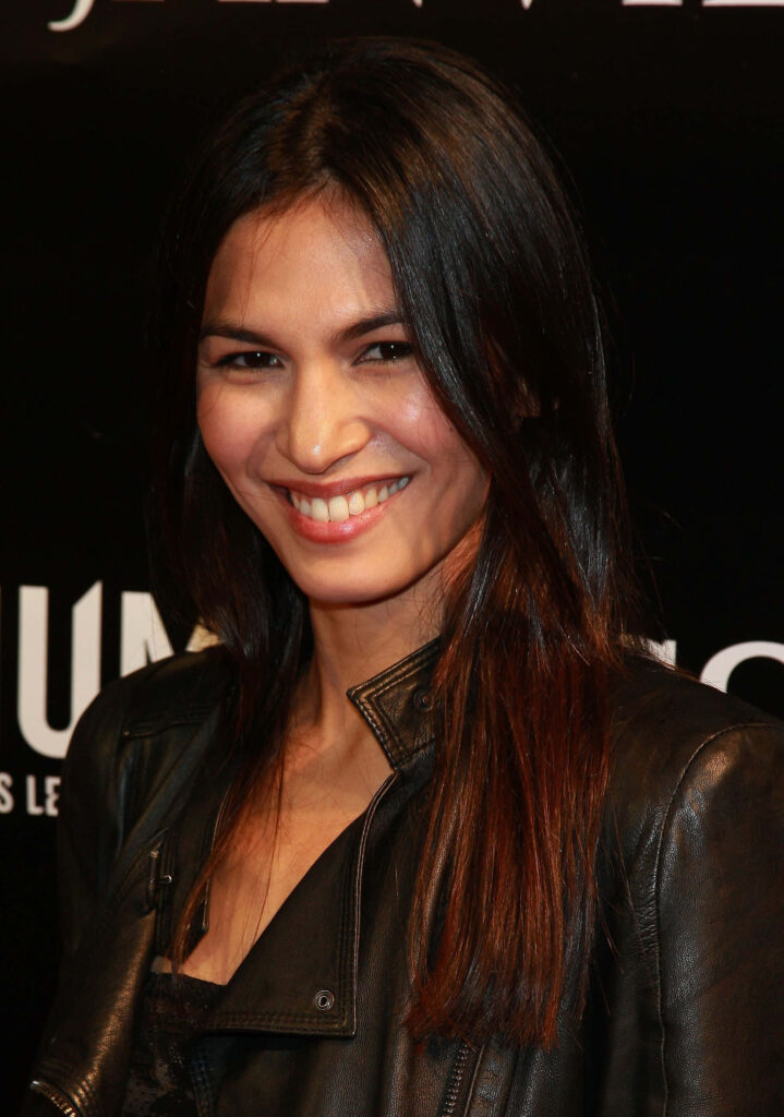 Elodie Yung confident pose warm smile leather jacket dark background modern stylish wallpaper