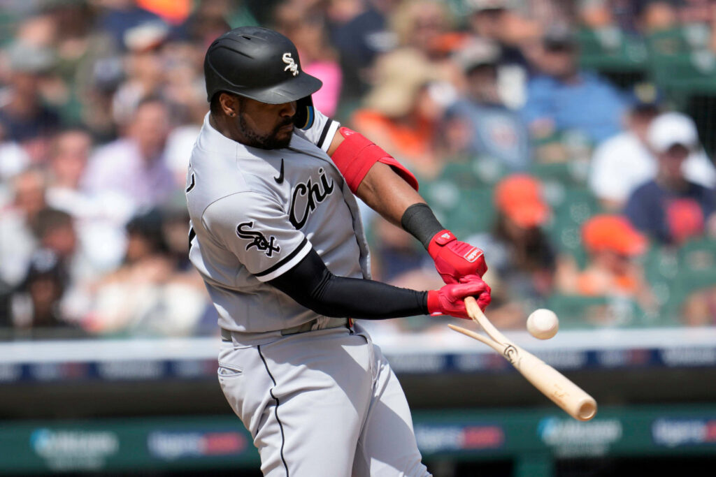 Eloy Jiménez Chicago White Sox mid-swing powerful batting stance vibrant red gloves action shot Wallpaper