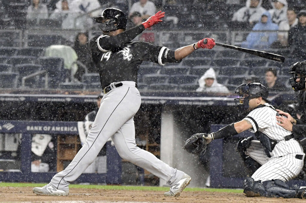 Eloy Jiménez powerful swing in rainy baseball game with raindrops dynamic action background Wallpaper