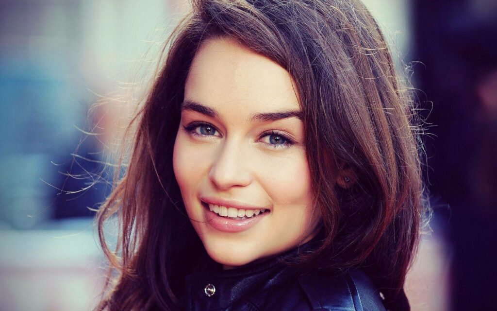 Emilia Clarke smiling portrait with natural light blurred background warm approachable mood Wallpaper