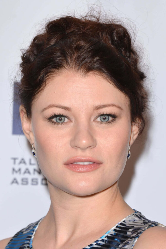 Emilie de Ravin close up with soft makeup and striking blue eyes elegant light background wallpaper