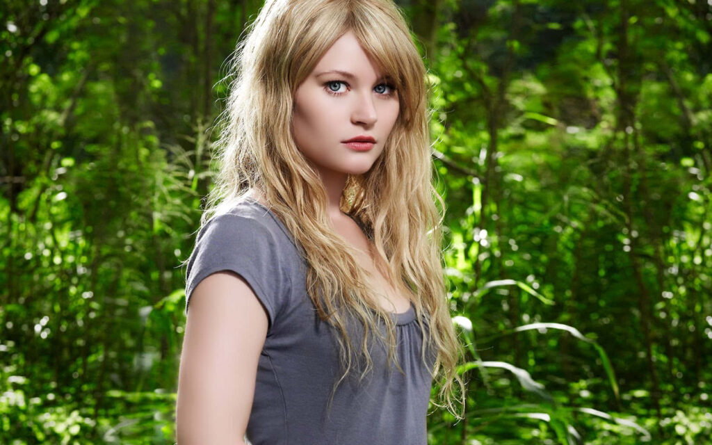 Emilie de Ravin portrait in lush green foliage with blonde hair and clear blue eyes natural light Wallpaper