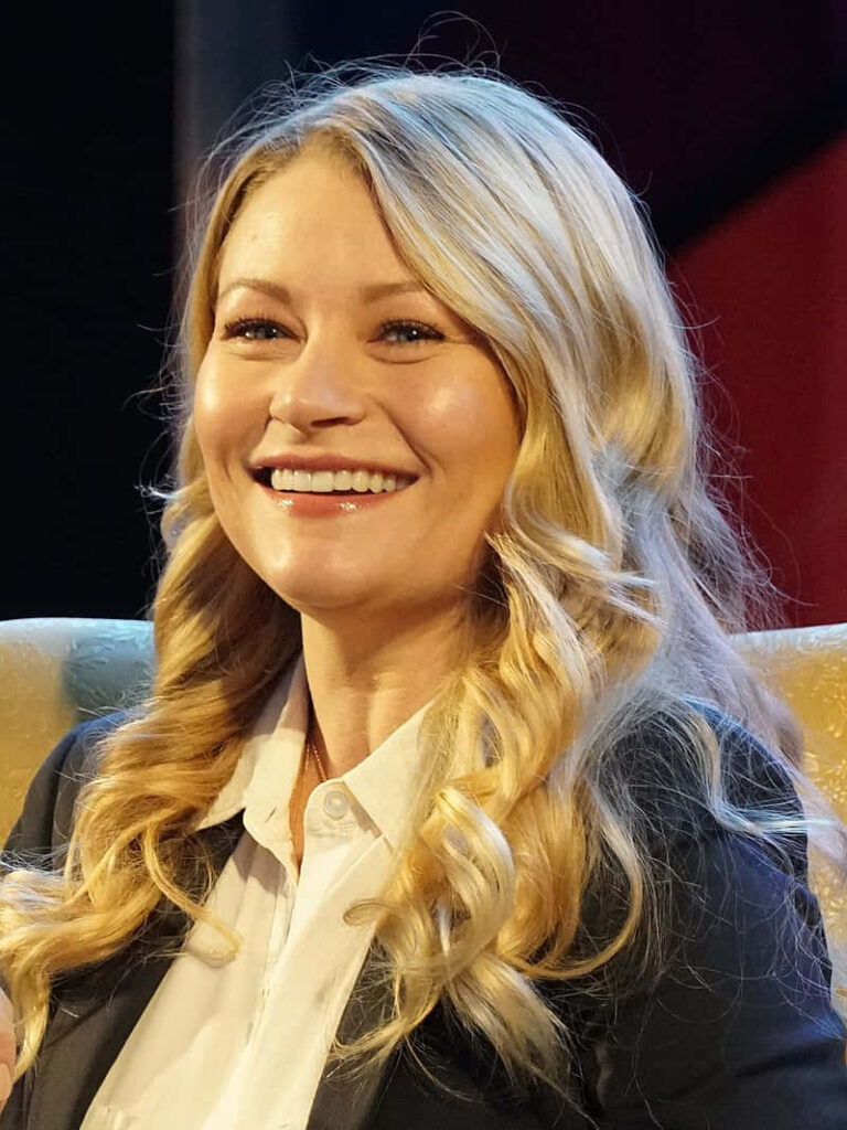 Emilie de Ravin smiling wearing white blouse and dark blazer with soft waves and indoor background Wallpaper