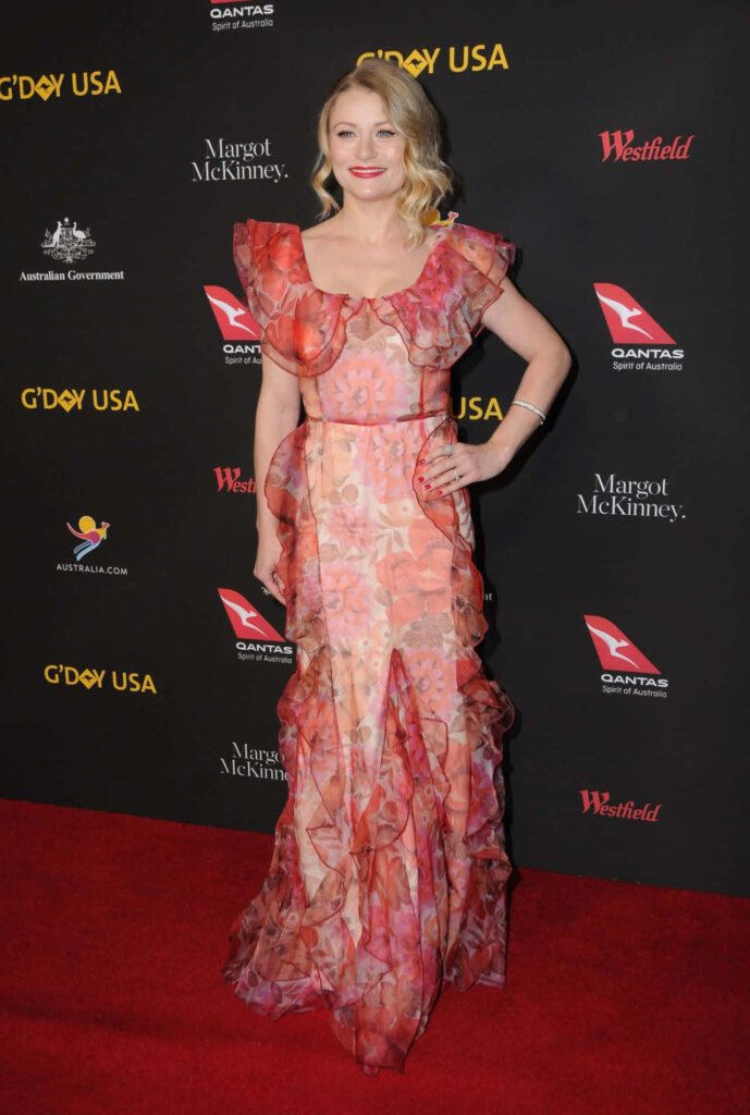 Emilie de Ravin in flowing floral ruffled gown on red carpet striking glamorous celebrity wallpaper