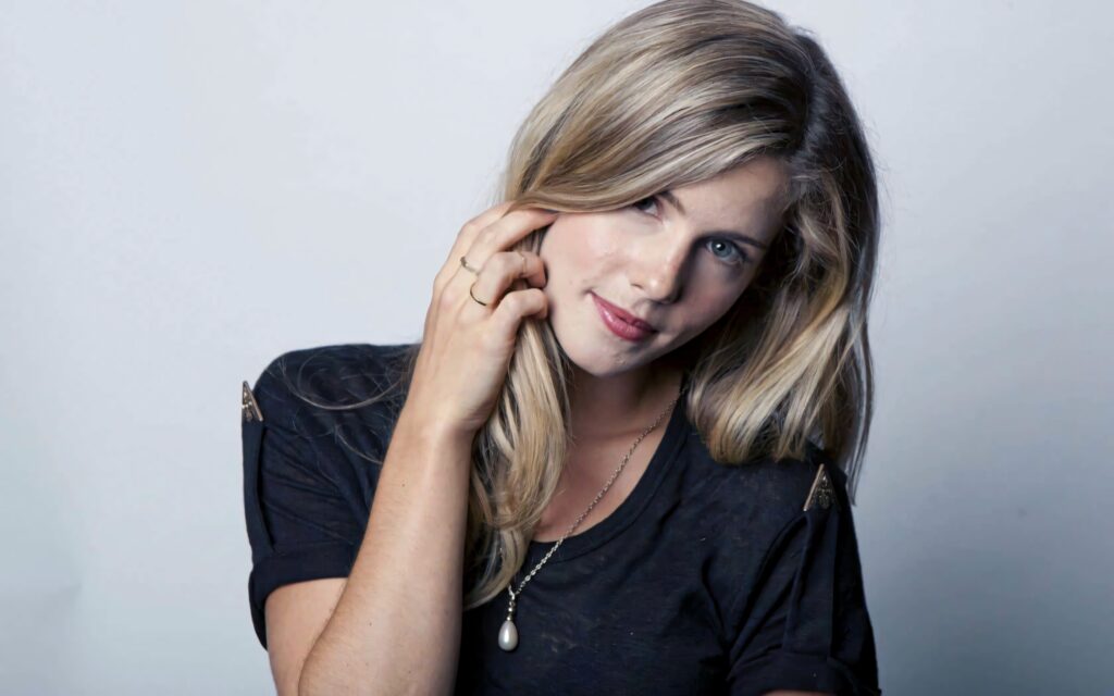 Emily Bett Rickards portrait with blonde hair and natural makeup on soft light background wallpaper
