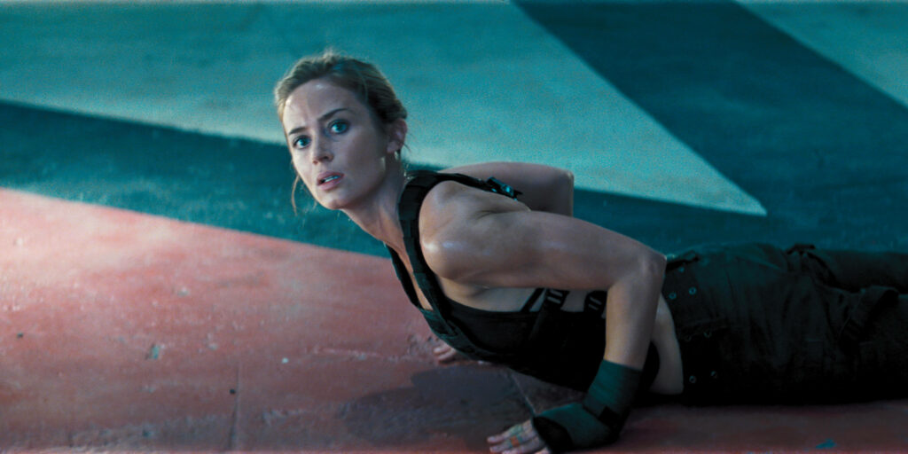 Emily Blunt action scene wallpaper showcasing strength determination high energy background